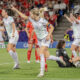 Ada Hegerberg points in the distance as she runs to celebrate her goal, Switzerland players and the goalkeeper look down, distraught in the background.