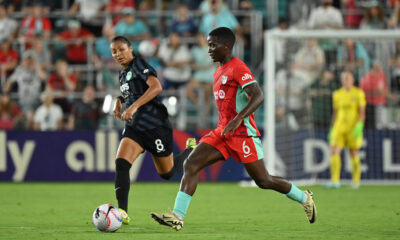 Two players dribble the ball on the soccer field