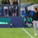 New Boston Legacy FC coach Filipa Patão standing on the pitch during a match and watching the action from the sideline.